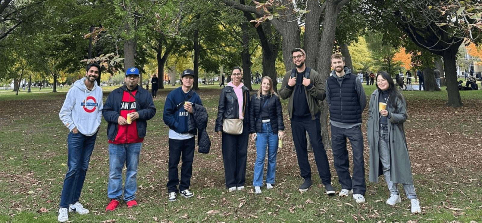 A large DesignWalks group posing together under the trees in Trinity Bellwoods park in autumn