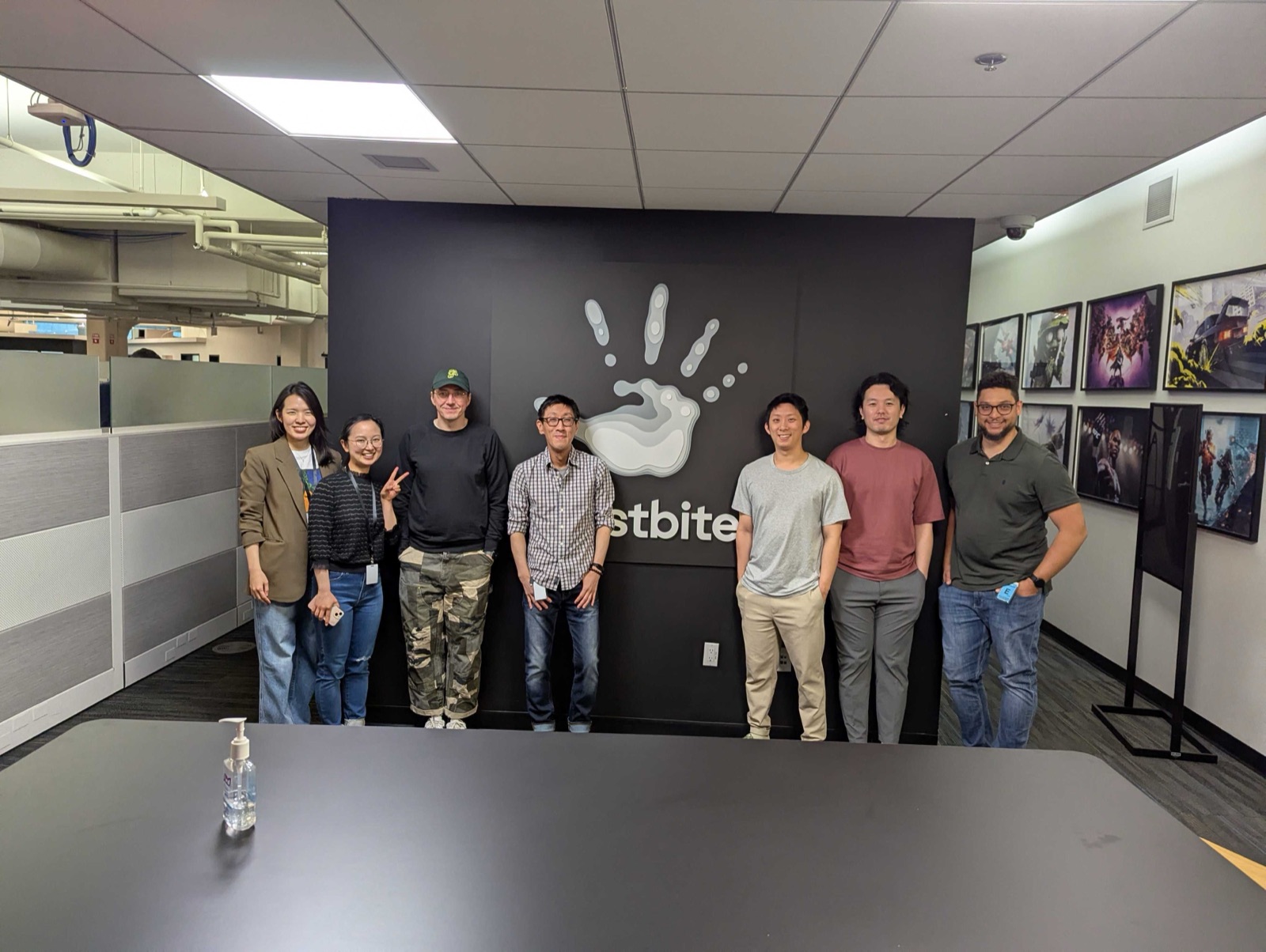 Christopher Miller with the EA Frostbite experience design team in front of the Frostbite logo wall